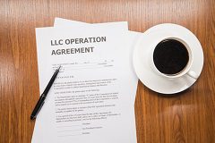 A document outlining LLC taxes on a table next to a cup of coffee.