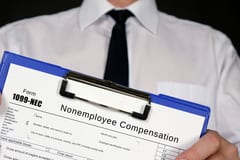 A tax pro holding a clip board with a 1099-NEC