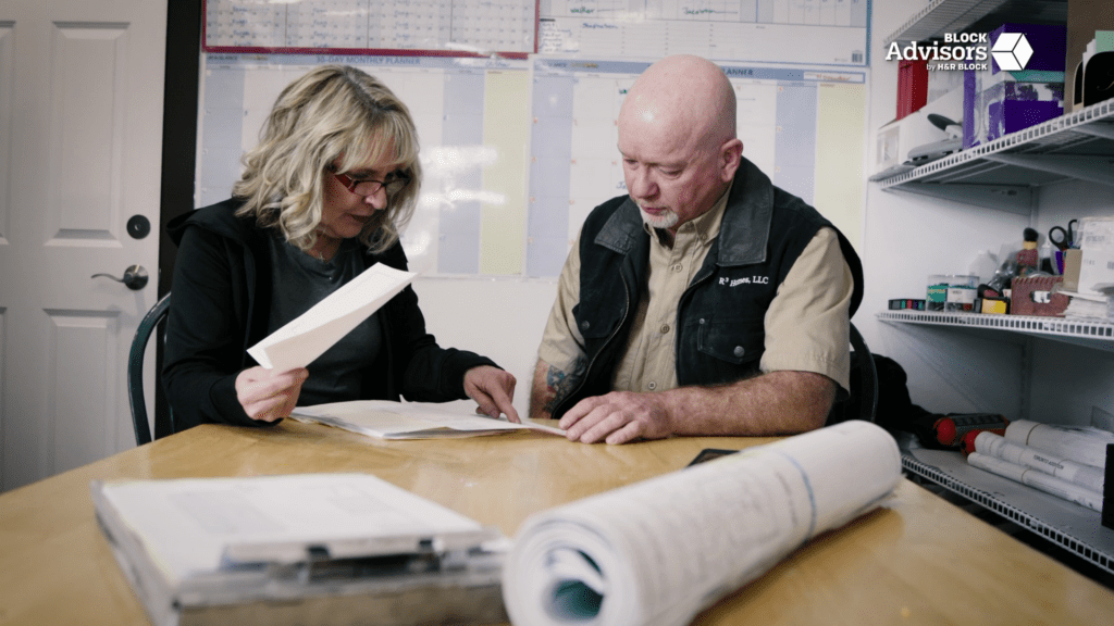 Leanne Knapp and Jim Erickson review a stack of business paperwork in their small business office.