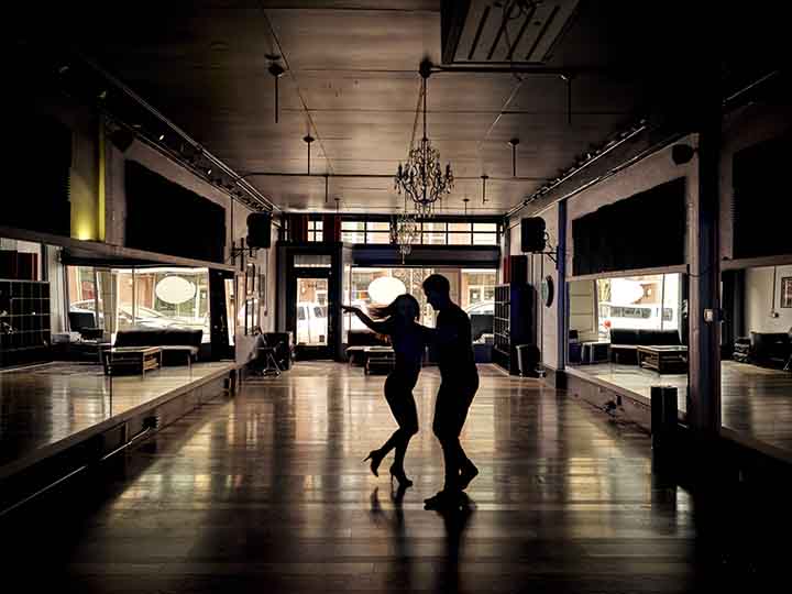 Michael Cahn instructing a dancer in his Salsa studio.