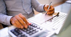 A small business owner writing payroll checks