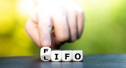 FIFO vs. LIFO Inventory Management with index finger of a man pointing to letters
